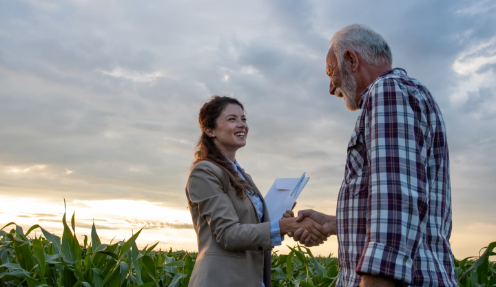 man and woman shaking hands in farm field