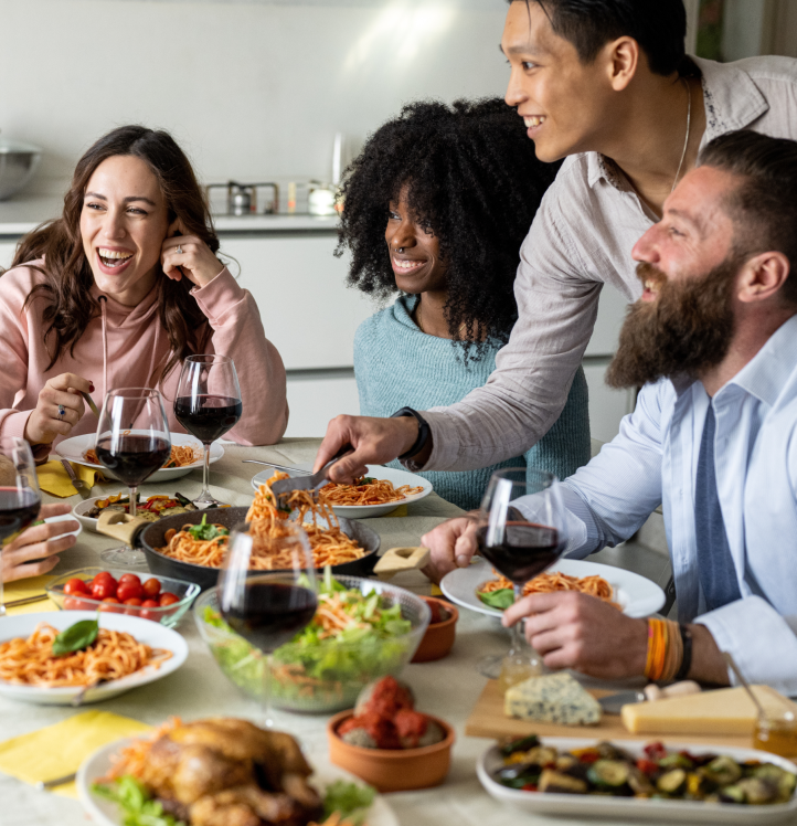 group of people eating food together at dining table