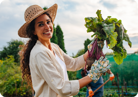 woman smiling with vegetable in farm field