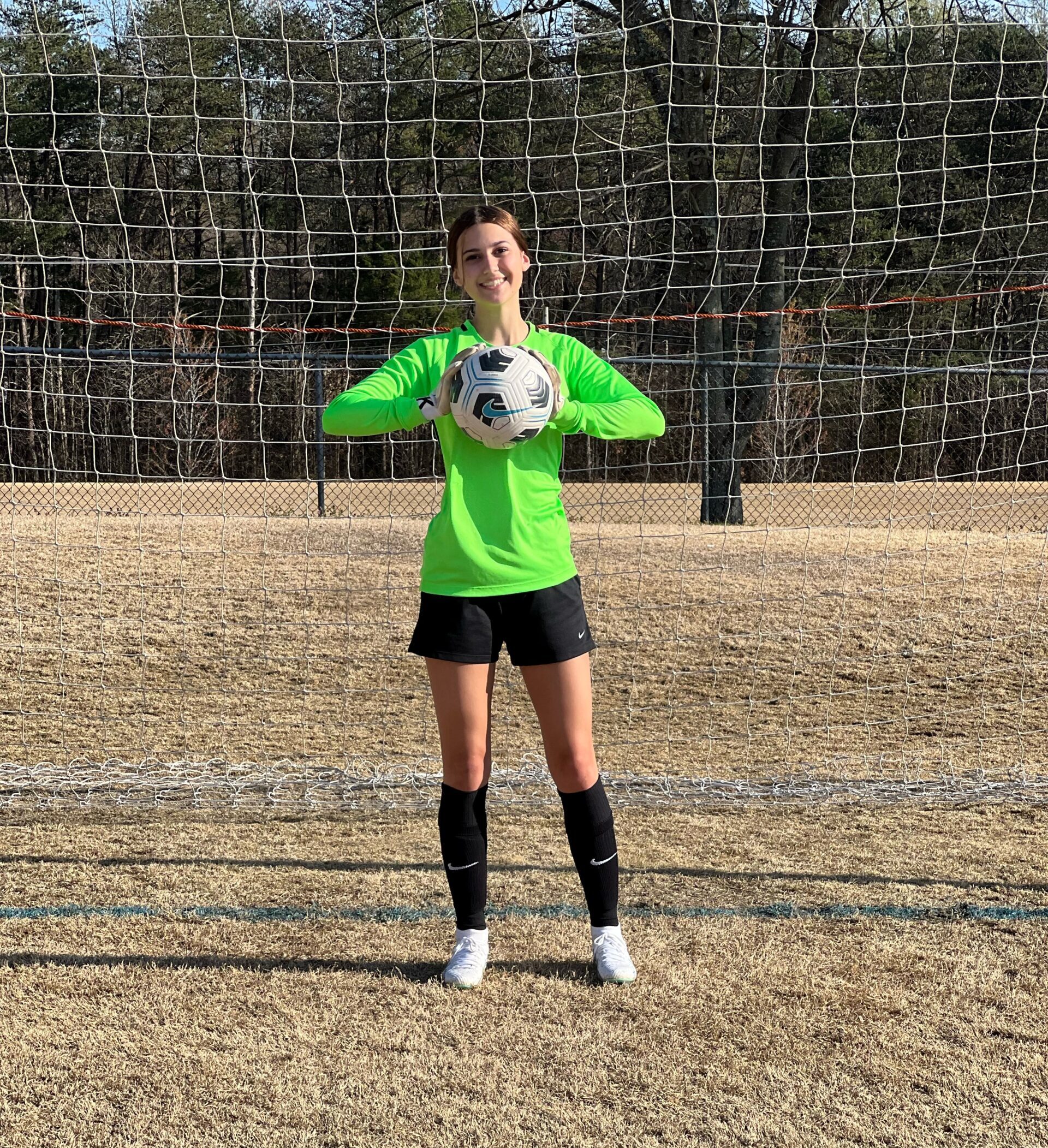 girl holding soccer ball