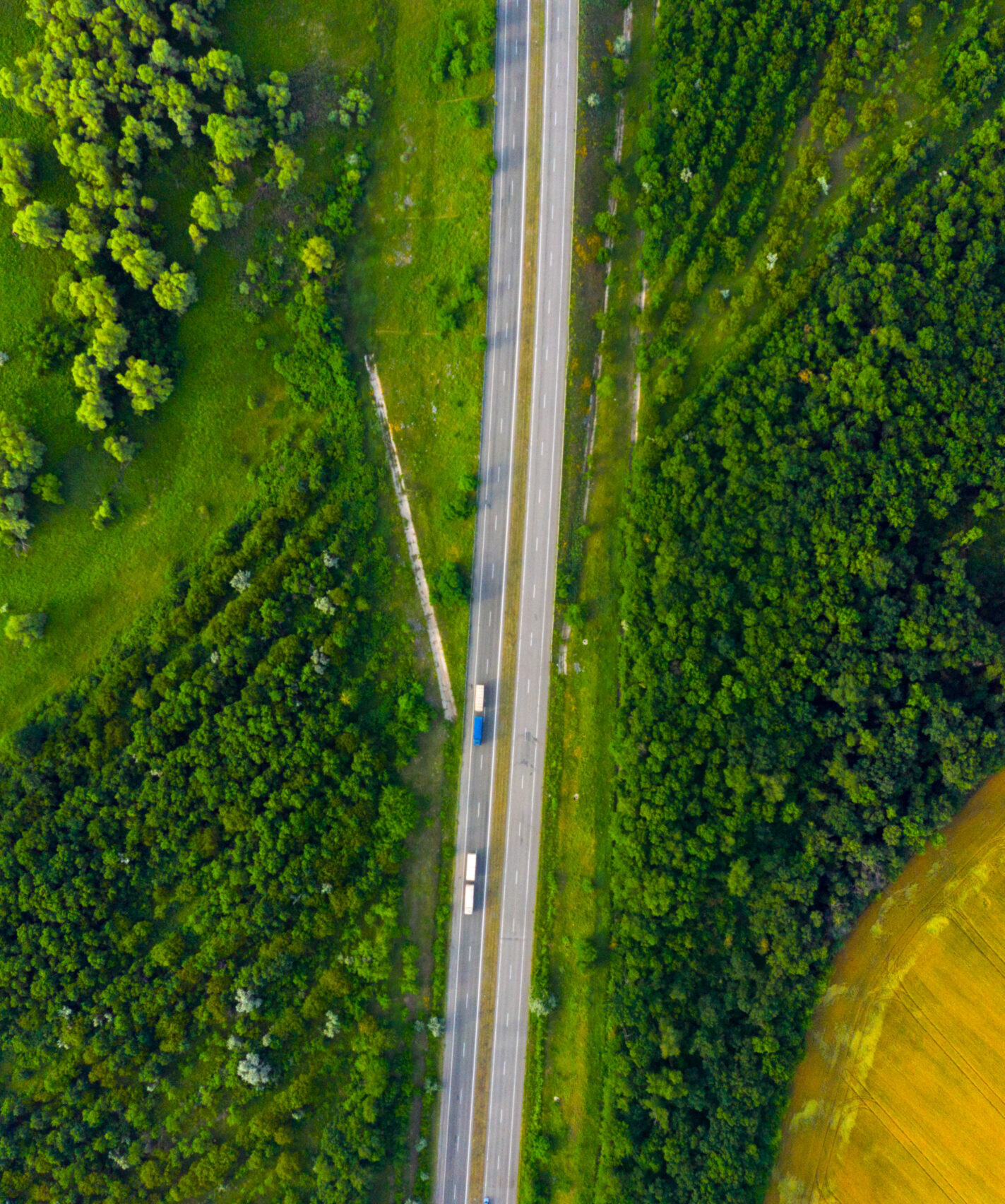 overhead shot of road with 2 trucks driving on it