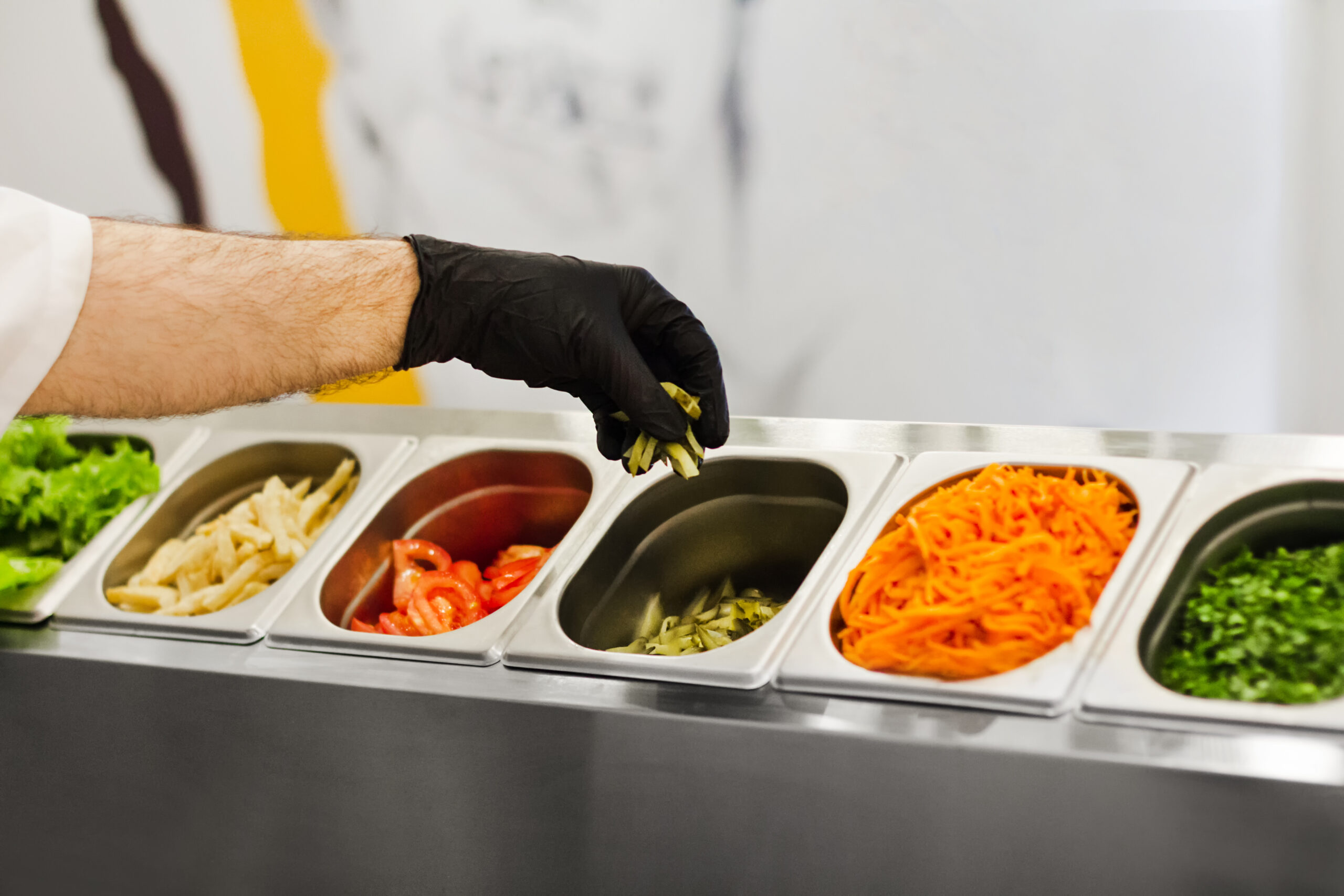 Hand grabbing vegetables out of container