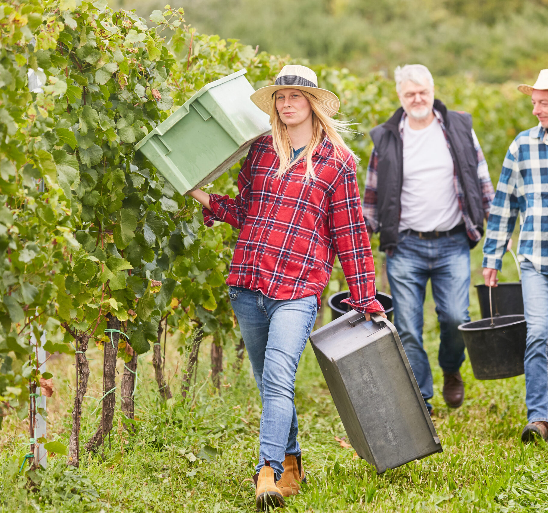 woman carrying containers in field